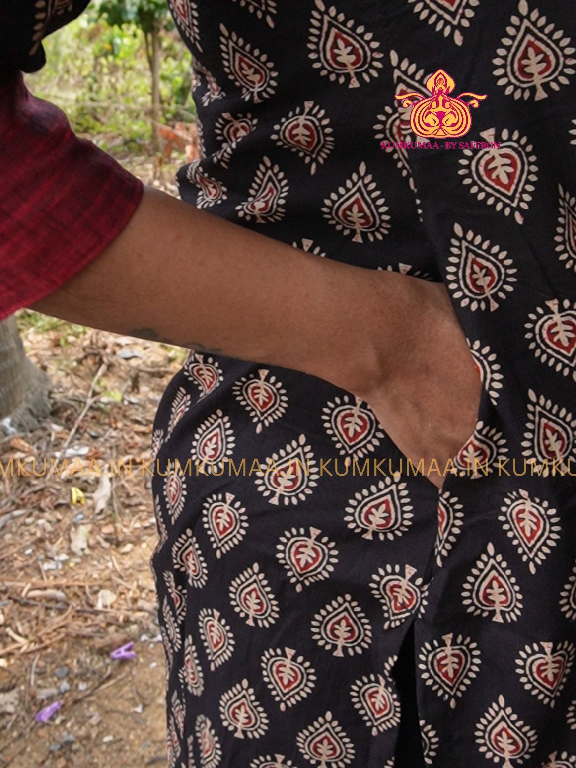 Person wearing a dark patterned garment with a blurred background