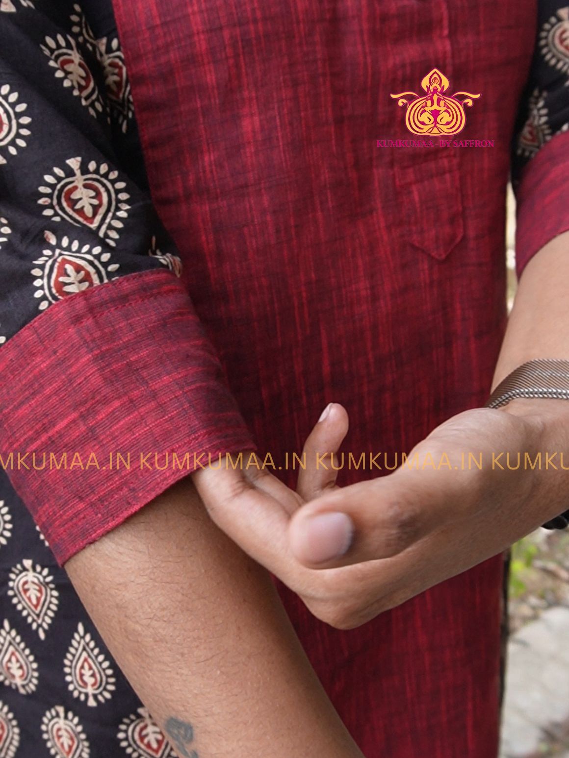 Close-up of a person wearing a red and black traditional outfit with a visible brand logo.
